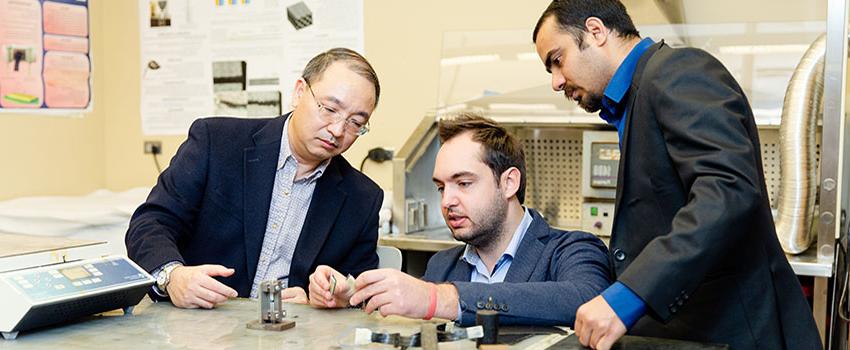 Engineering students working in lab with faculty